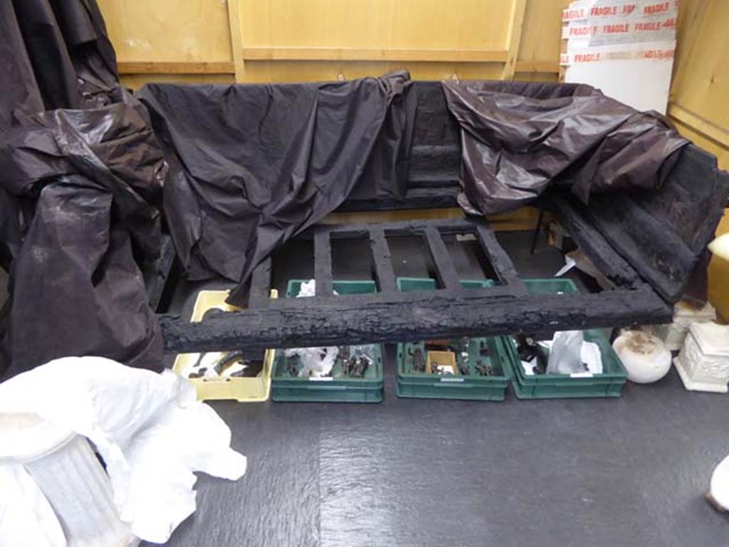 Ins. Orientalis II.10, Herculaneum. September 2016. Carbonised wooden bed with high back. Photo courtesy of Michael Binns.
According to De Carolis – At Herculaneum, eight carbonised wooden beds had been found, of which one (above) which was characterised by having three high backs was decorated with geometric motifs made with the technique of veneering with various woods.
See De Carolis, E. (2007). Il mobile a Pompei ed Ercolano: letti tavoli sedie e armadi. Rome, “L’ERMA” di Bretschneider, (p.86).